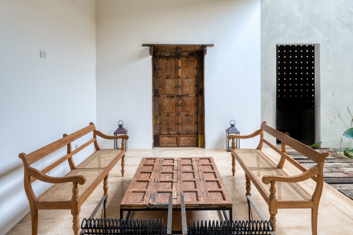 Rows of traditional Portuguese carafes and a handful of planters' chairs are slotted into nooks